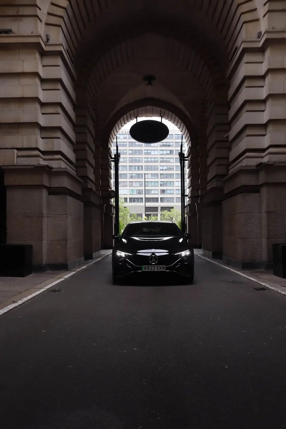 Mercedes EQE framed by a stone archway in London