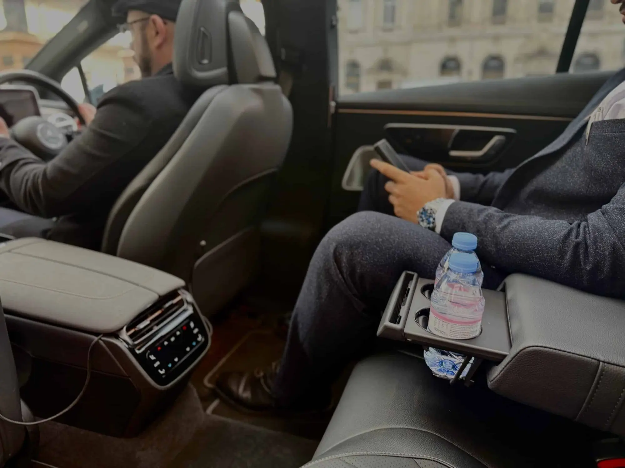 Business passenger working in the rear seat of an electric chauffeur car