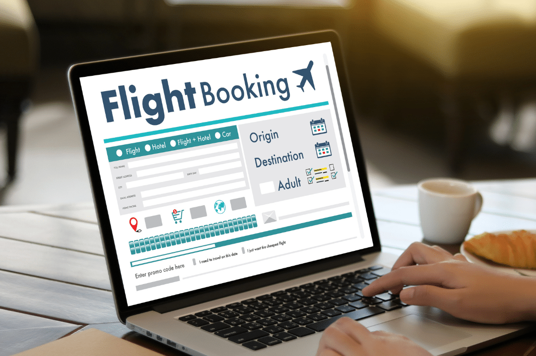 A laptop screen showing a booking page while hand are on the keyboard  