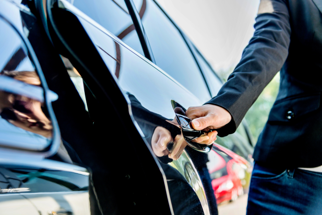 A hand grips a car key, indicating readiness to access the vehicle
